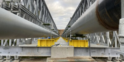 Bridge assembled over land and translated using rollers on towers across the Oatka Creek.