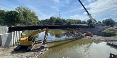 Execution of steel bridge erection, employing specialized erection procedures to circumvent overhead utilities