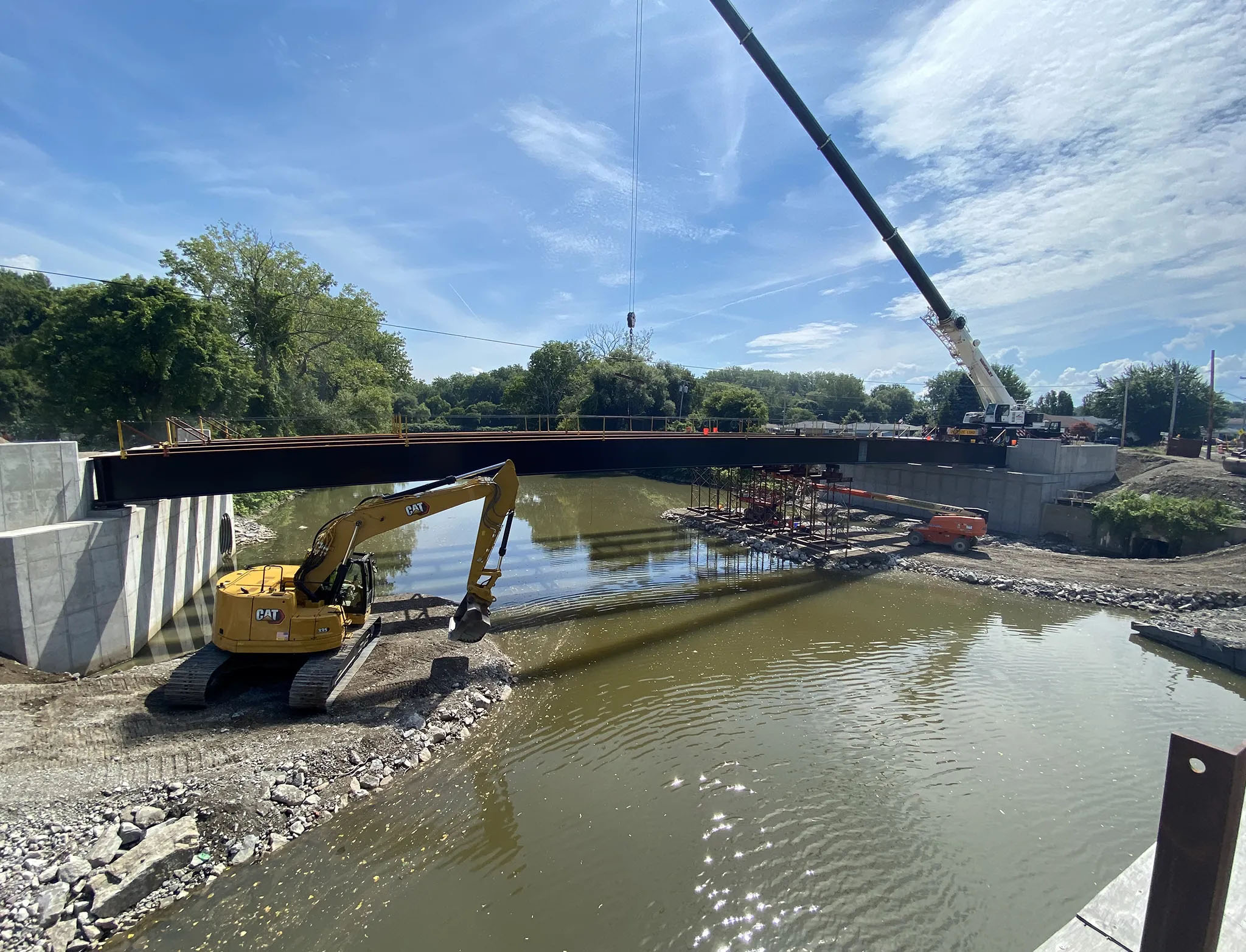 Execution of steel bridge erection, employing specialized erection procedures to circumvent overhead utilities